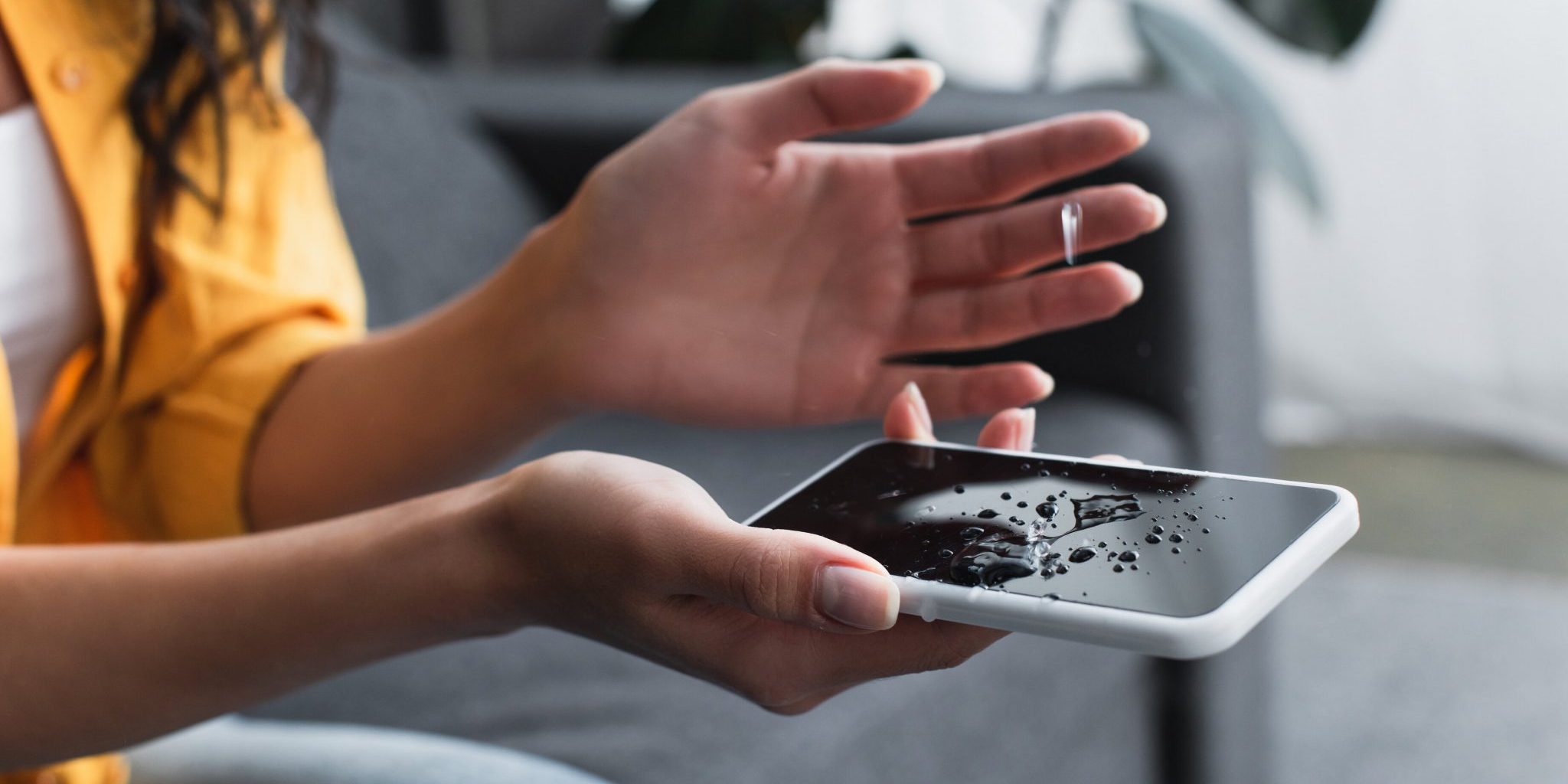 Partial view of woman holding water damaged smartphone water damage